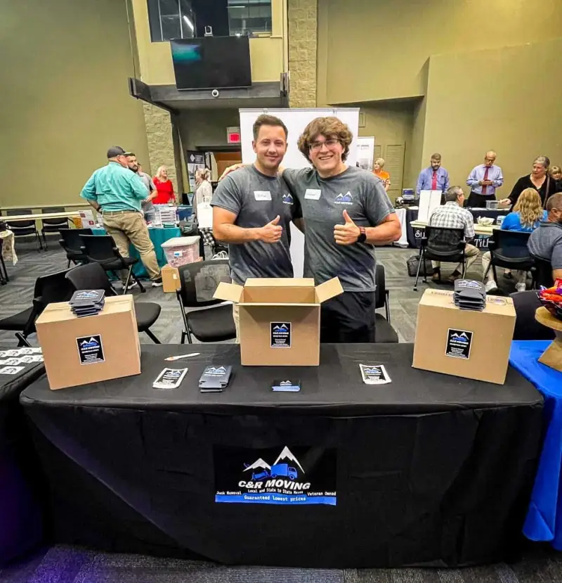 Two C&R Moving crew members at a local business expo booth